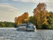 Weiße Flotte im Herbst: Ein Schiff der Weißen Flotte fährt auf der Ruhr, im Hintergrund herbstliche Natur mit rot-gelb gefärbten Blättern an den Bäumen